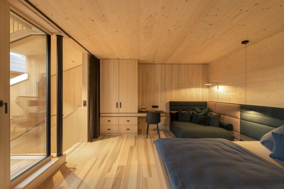 Geräumiges Hotelzimmer mit Balkon, Sitzecke, Schreibtisch und Holzwänden im 4 Sterne Hotel Oswalda Hus Kleinwalsertal.