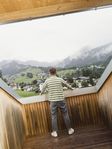 Mann auf einem Balkon mit Bergblick im Hotel Oswalda Hus Kleinwalsertal.