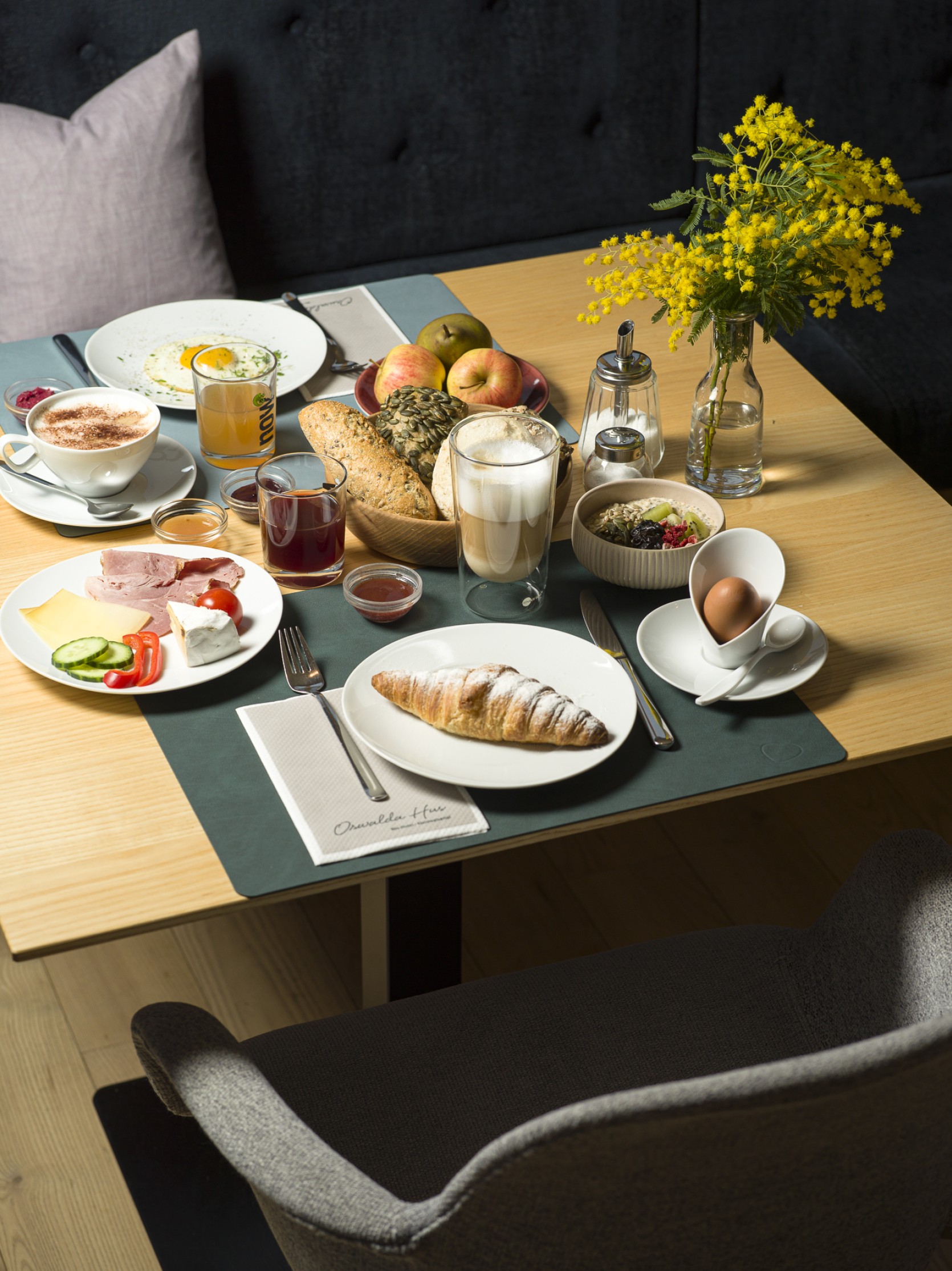 Bio Frühstück mit Obst, Gemüse, Gebäck und Eiern auf einem gedeckten Tisch im 4 Sterne Hotel Oswalda Hus im Kleinwalsertal.