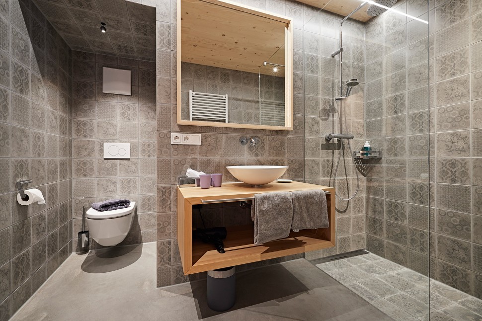 Badezimmer mit ebeberdiger Dusche im Biohotel oswalda hus Vorarlberg.