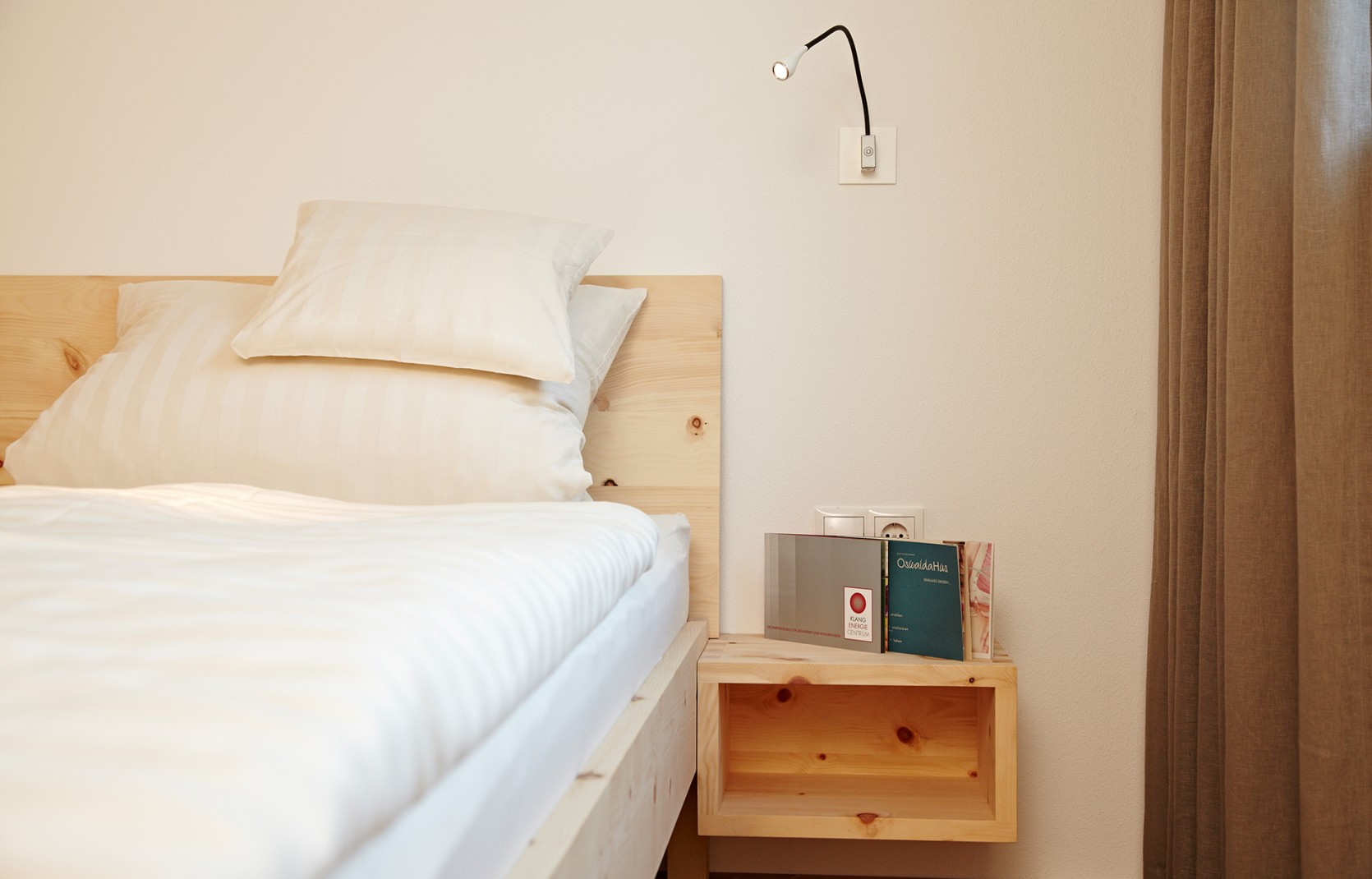 Geräumiges Hotelzimmer mit Holzbett im 4-Sterne-Hotel Oswalda Hus im Kleinwalsertal.