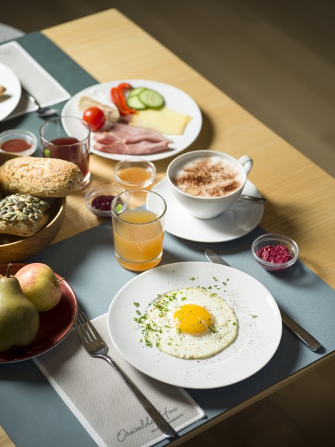Bio Frühstück mit Obst, Gemüse, Gebäck und Eiern auf einem gedeckten Tisch im 4 Sterne Hotel Oswalda Hus im Kleinwalsertal.