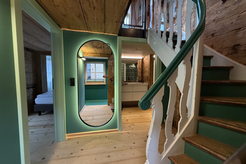 Eingangsbereich mit grünen Wänden und Altholz im Oswalda Hus Ferienhaus im Kleinwalsertal.