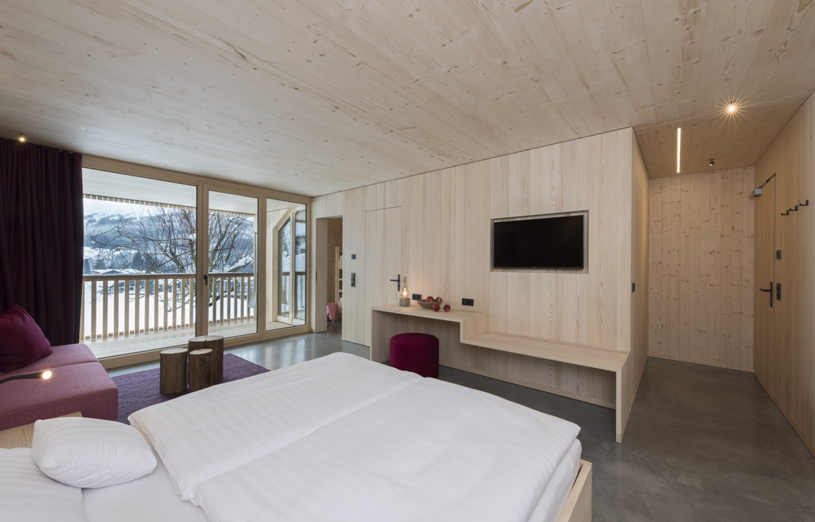 Geräumiges Hotelzimmer mit Balkon, Sitzecke, Schreibtisch und Holzwänden im 4 Sterne Hotel Oswalda Hus Kleinwalsertal.