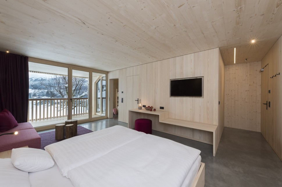 Geräumiges Hotelzimmer mit Balkon, Sitzecke, Schreibtisch und Holzwänden im 4 Sterne Hotel Oswalda Hus Kleinwalsertal.